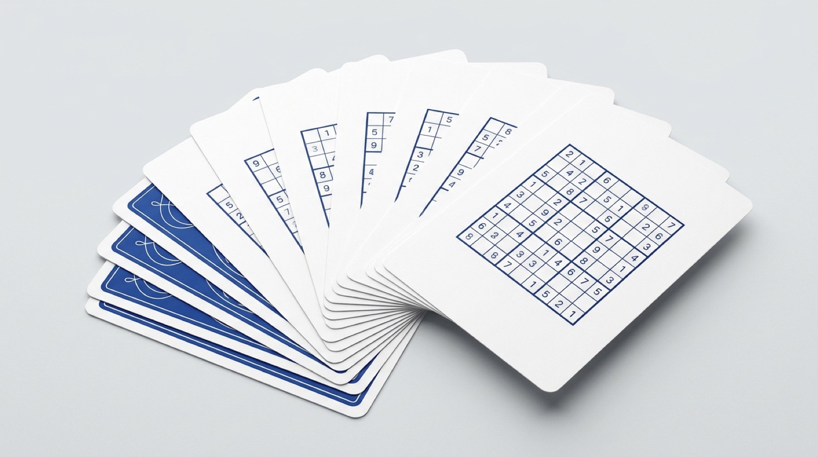 A premium deck of sudoku playing cards fanned out, white faces with royal blue backs